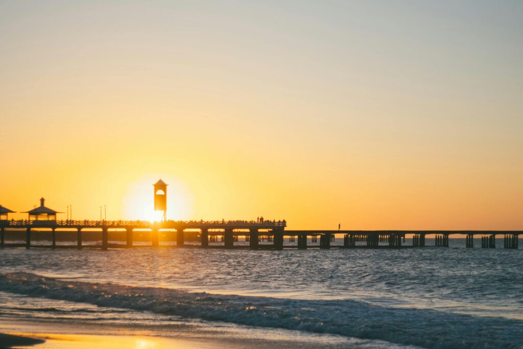 Tranquil sunset view over a pier in Fortaleza, Brazil, with warm colors and serene sea.